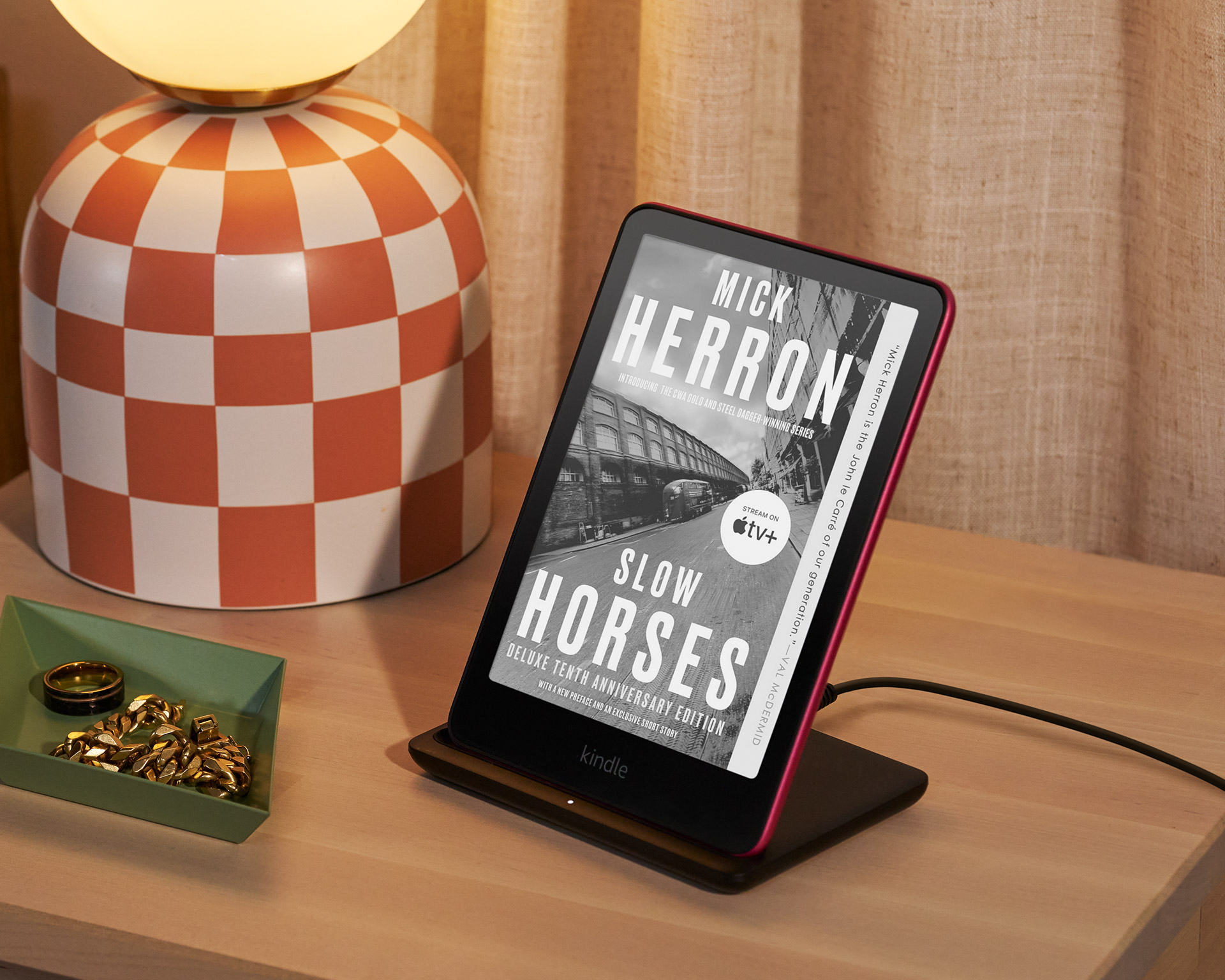 Kindle Paperwhite Signature Edition is on the Made for Amazon Wireless Charging Dock on an end table.
