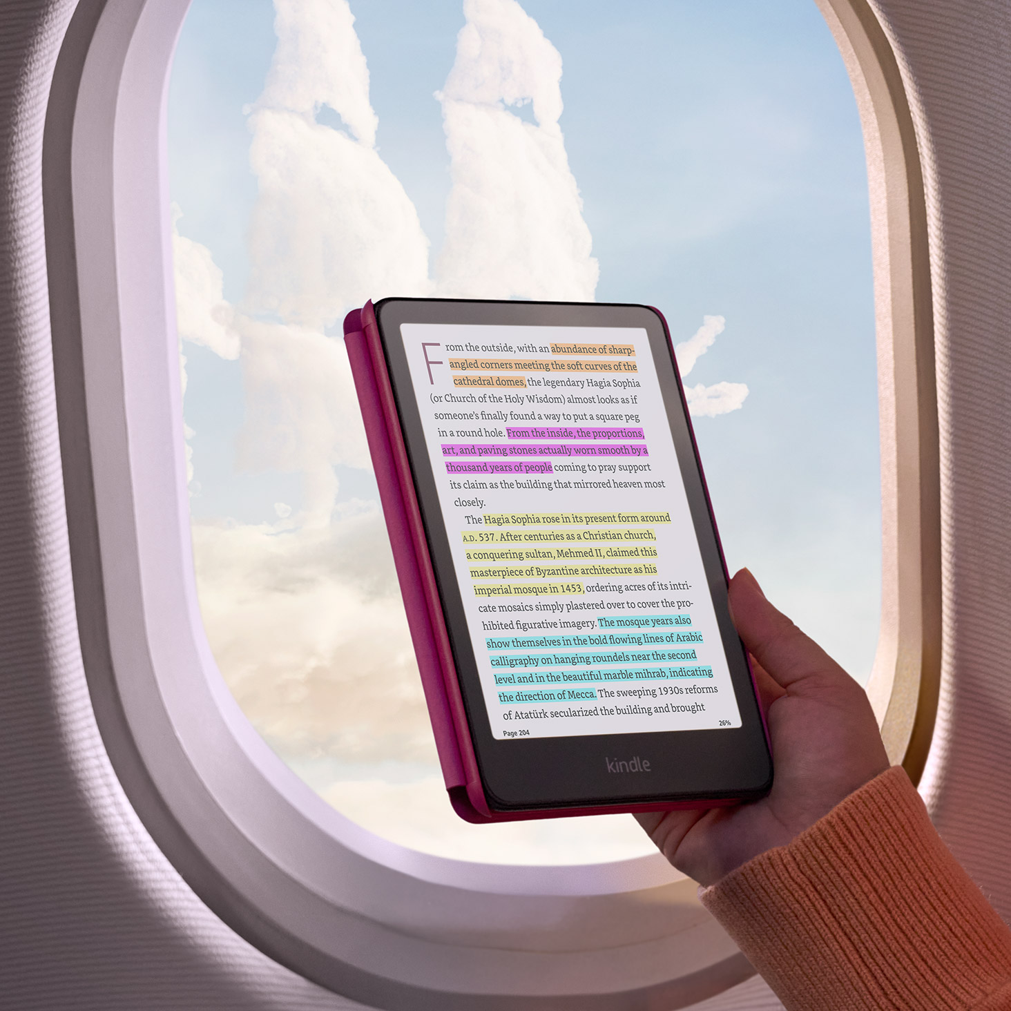 A reader on a plane holds Kindle Colorsoft in the window. Highlighted text is on screen.